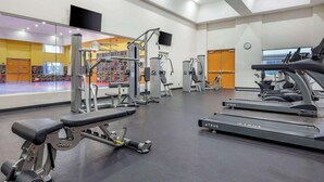 A modern gym with various exercise equipment, including treadmills and weight machines, and a mirrored wall reflecting the space. - Hilton Vacation Club Palm Canyon (Palm Springs)
