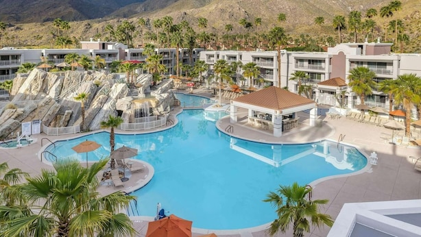 A resort with a large central pool, palm trees, and a mountainous backdrop. - Hilton Vacation Club Palm Canyon (Palm Springs)