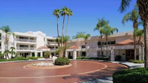 A hotel with a central courtyard, palm trees, and a multi-story building with balconies. - Hilton Vacation Club Palm Canyon (Palm Springs)