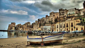 A coastal town with historic buildings, a sandy beach, and a boat. - Visitsicilia Donn'Anna 1 (Castellammare del Golfo)