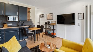 A compact living space with a kitchenette, dining area, and a sofa. - Charysma: Aurum Suite | modern & elegant design | parking lot | terrace (Hameln)