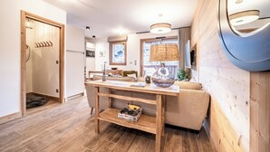 Een moderne keuken met houten vloeren, een houten eettafel en een bank.