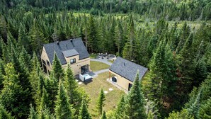 Een modern huis omringd door dicht bos.