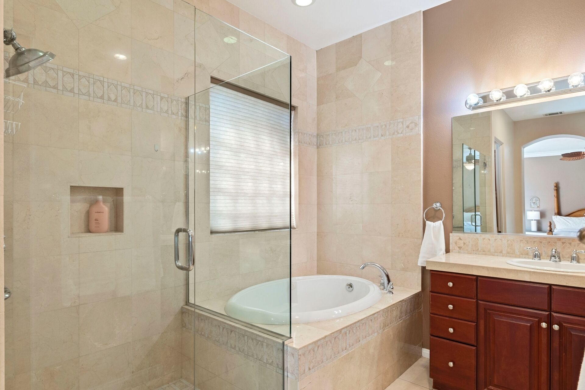 Een moderne badkamer met een douche met glazen wand, een vrijstaand bad en een wastafel met spiegel.