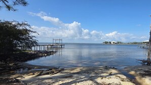 A calm waterfront with a pier extending into the water, surrounded by trees and a sandy beach. - Perdido Key Beach !!!  Spacious 3/2, kid-pet friendly, boatramp, kids park=5min (Pensacola)