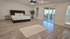 A bedroom with a wooden bed, a white rug, and a ceiling fan. - Perdido Key Beach !!!  Spacious 3/2, kid-pet friendly, boatramp, kids park=5min (Pensacola)