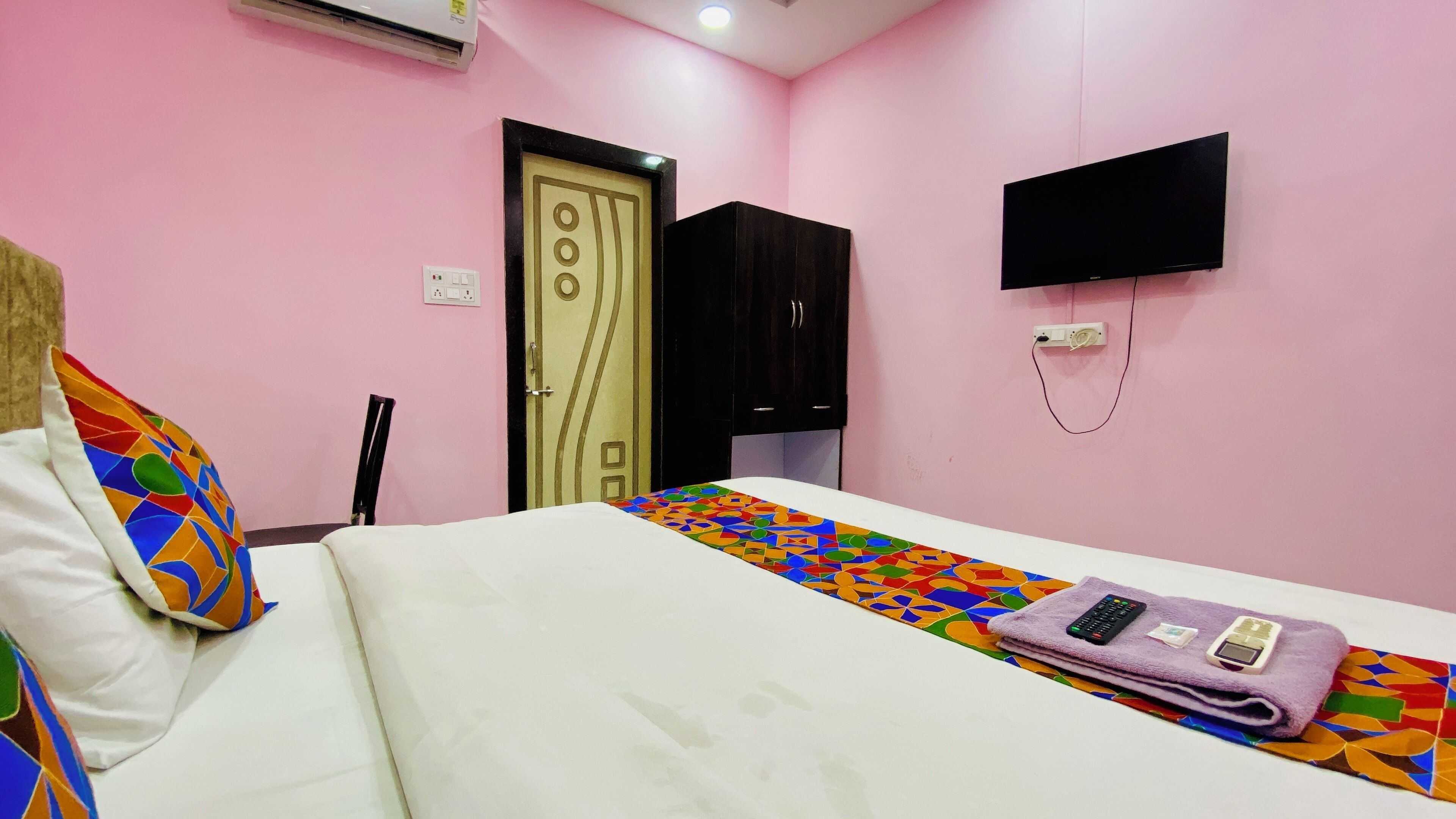 A bedroom with a bed, a TV, and a wardrobe.