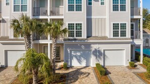 A multi-story residential building with a symmetrical facade, multiple balconies, and a garage.
