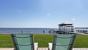 Two green chairs facing a pier extending into a body of water, with a gazebo-like structure at the end. - Hidden Gem, New Patio, Private Dock (Santa Rosa Beach)