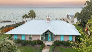 A coastal house with a metal roof, a front porch, and a view of the sea. - Hidden Gem, New Patio, Private Dock (Santa Rosa Beach)