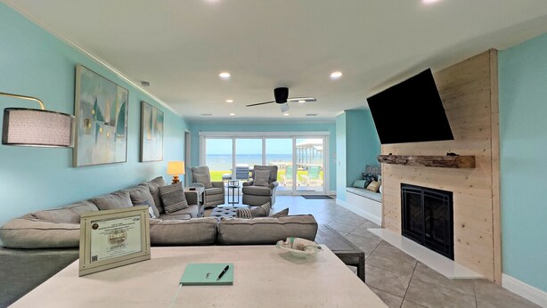 A modern living room with a sectional sofa, a fireplace, and a large TV. - Hidden Gem, New Patio, Private Dock (Santa Rosa Beach)