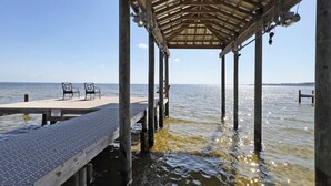 A wooden pier with a covered seating area and a warning sign. - Hidden Gem, New Patio, Private Dock (Santa Rosa Beach)