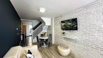 Casa de ciudad de diseñador | Área de sala de estar | Smart TV de 65 pulgadas con canales vía satélite