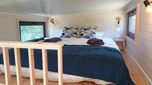 A cozy bedroom with a wooden headboard, a bed with a blue bedspread, two pillows, a bedside table, and a nightstand. - Sistelo - Sleeps4 - Naturalpool- Garden - Parking (Arcos de Valdevez)