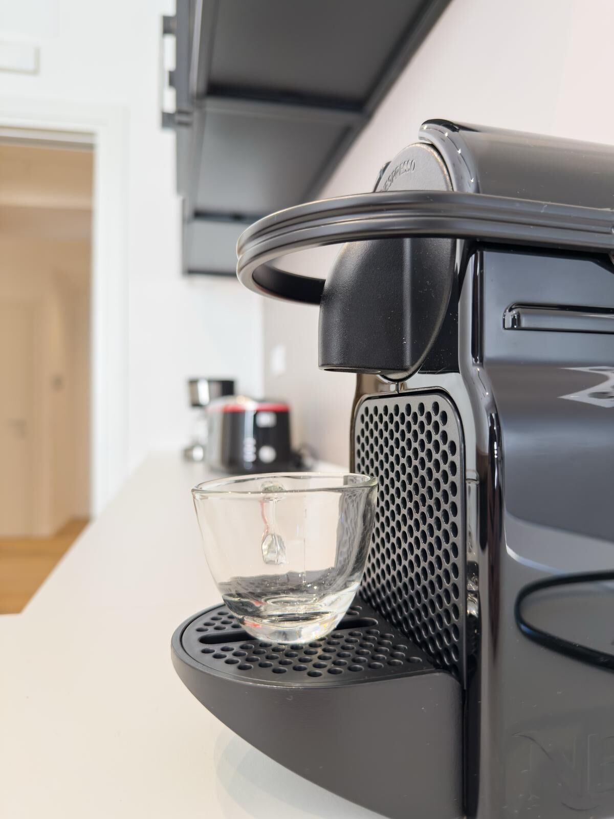 A coffee maker with a glass carafe on its drip tray.