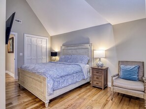 Ein Schlafzimmer mit einem Bett, Nachttischen, einem Sessel und einem Kleiderschrank.