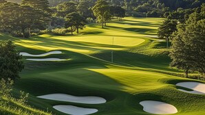 Een golfbaan met verzorgde greens, zandbunkers en een vlag.