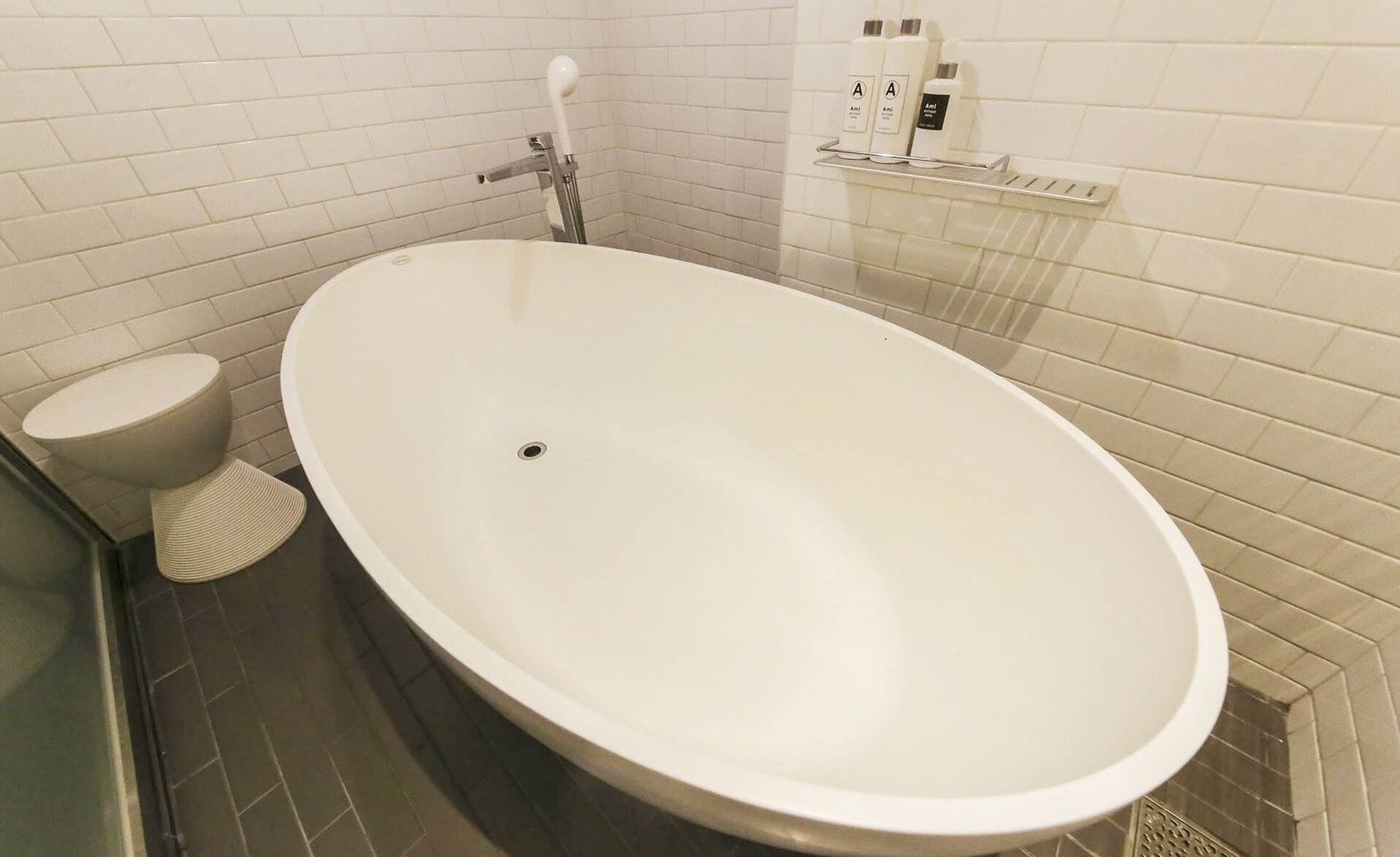 A modern bathroom with a freestanding bathtub, a toilet, and a shower area.