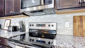 A kitchen with stainless steel appliances, including a microwave, toaster, and oven.