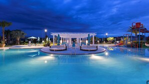Une piscine dotée d’un espace de détente central et d’une aire de jeux pour enfants.