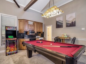 A pool table with a red felt surface, a pool cue, and a white cue ball. - Bella Vista, Perfect for Groups,  Indoor Pool, 12,000 Sq. Ft !!! (Sevierville)