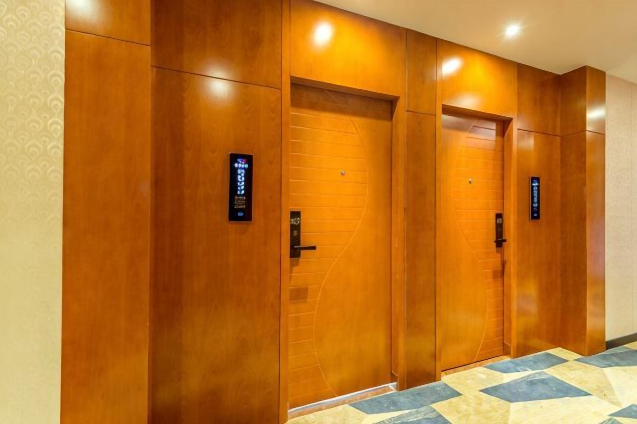 A hallway with wooden doors and a patterned carpet.