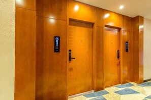 A hallway with wooden doors and a patterned carpet. - 168 Chain Hotel (Shenzhen Liantang Metro Station) (Shenzhen)