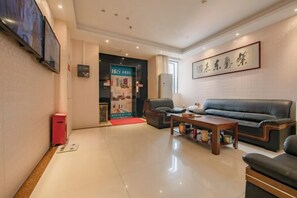 A modern living room with a sofa, a coffee table, and a television mounted on the wall. - 168 Chain Hotel (Shenzhen Liantang Metro Station) (Shenzhen)