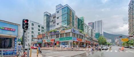 A city street with buildings, a crosswalk, and a traffic light.
