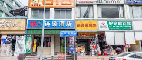 Una hilera de edificios comerciales con diversas fachadas, incluyendo un hotel y una tienda de conveniencia.