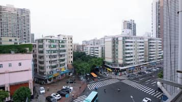 A cityscape with multi-story buildings, a crosswalk, and a bus.