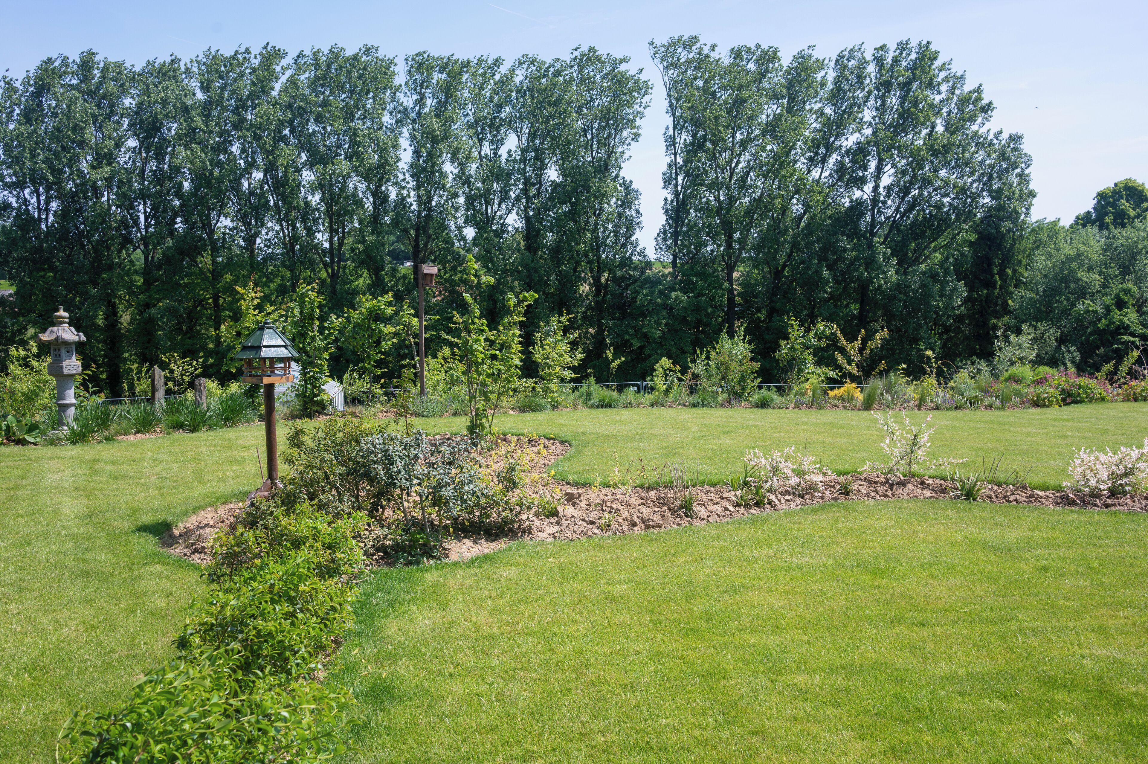 A well-maintained garden with a variety of plants and a small gazebo.