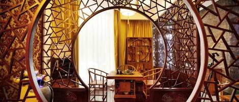 A traditional room with a circular wooden frame, a dining table, and chairs.