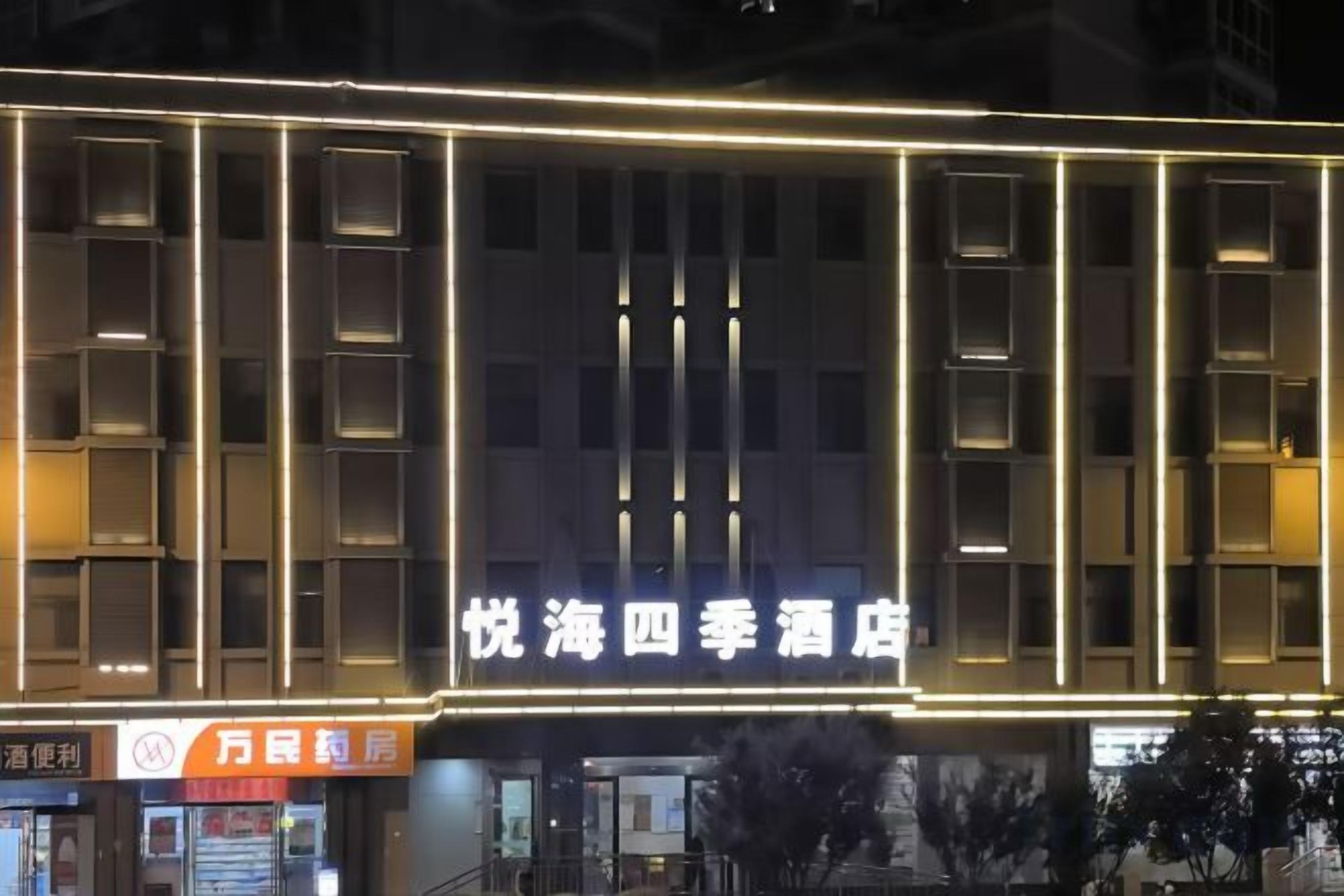 Un hôtel doté d’une façade moderne, d’une enseigne lumineuse et d’une architecture de fenêtres bien définie.