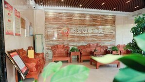 A hotel lobby with wooden furniture, a reception desk, and a wall with a textured design. - Four Seasons Hotel (Taiyuan l Liuxiang Shanxi Medical University Second Hospital) (Taiyuan)