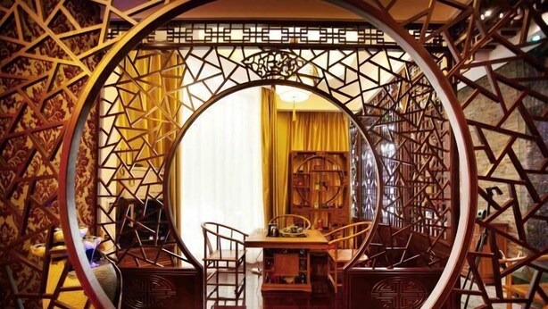 A traditional interior with a circular wooden frame, a dining table, and chairs. - Four Seasons Hotel (Taiyuan l Liuxiang Shanxi Medical University Second Hospital) (Taiyuan)