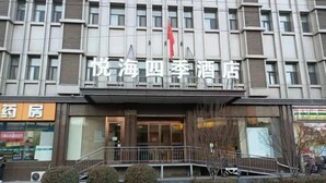 A hotel facade with a modern design, featuring a prominent entrance and a flag. - Four Seasons Hotel (Taiyuan l Liuxiang Shanxi Medical University Second Hospital) (Taiyuan)