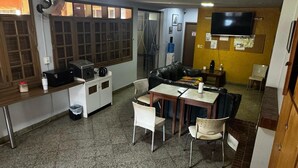 Un espacio habitable amplio con cocina, una mesa de comedor y un sofá de cuero negro.