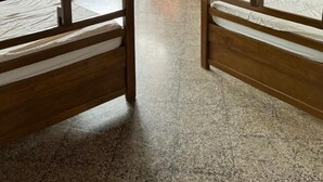 Una habitación con literas, un equipo de aire acondicionado, una ventana con vistas y un pequeño taburete naranja.