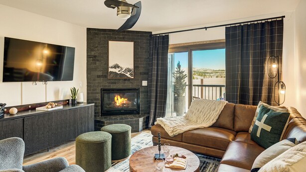 A modern living room with a fireplace, leather sofa, and a flat-screen TV. - Gorgeous Remodeled 3-Bedroom home in charming downtown Frisco with Private Sauna (Frisco)