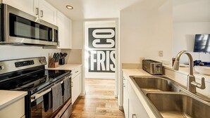 A modern kitchen with stainless steel appliances, a microwave, a toaster, and a sink. - Gorgeous Remodeled 3-Bedroom home in charming downtown Frisco with Private Sauna (Frisco)