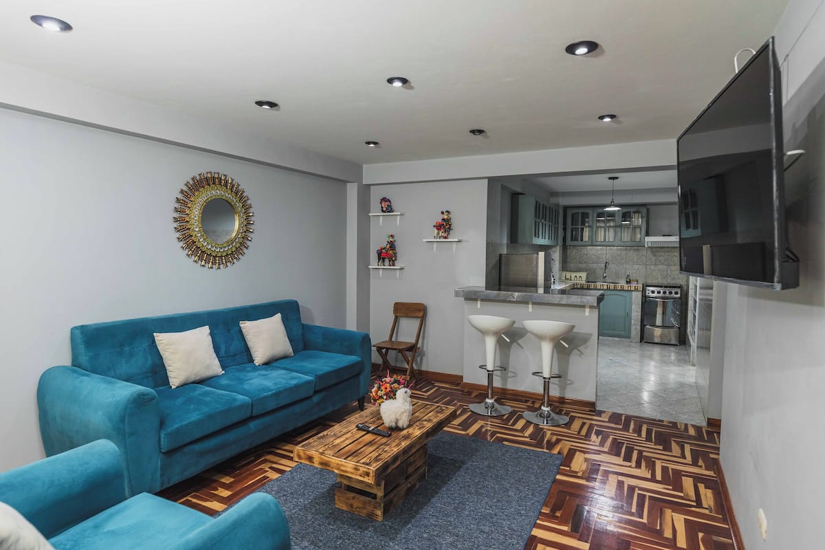 A living room with a blue sofa, wooden coffee table, and a TV.