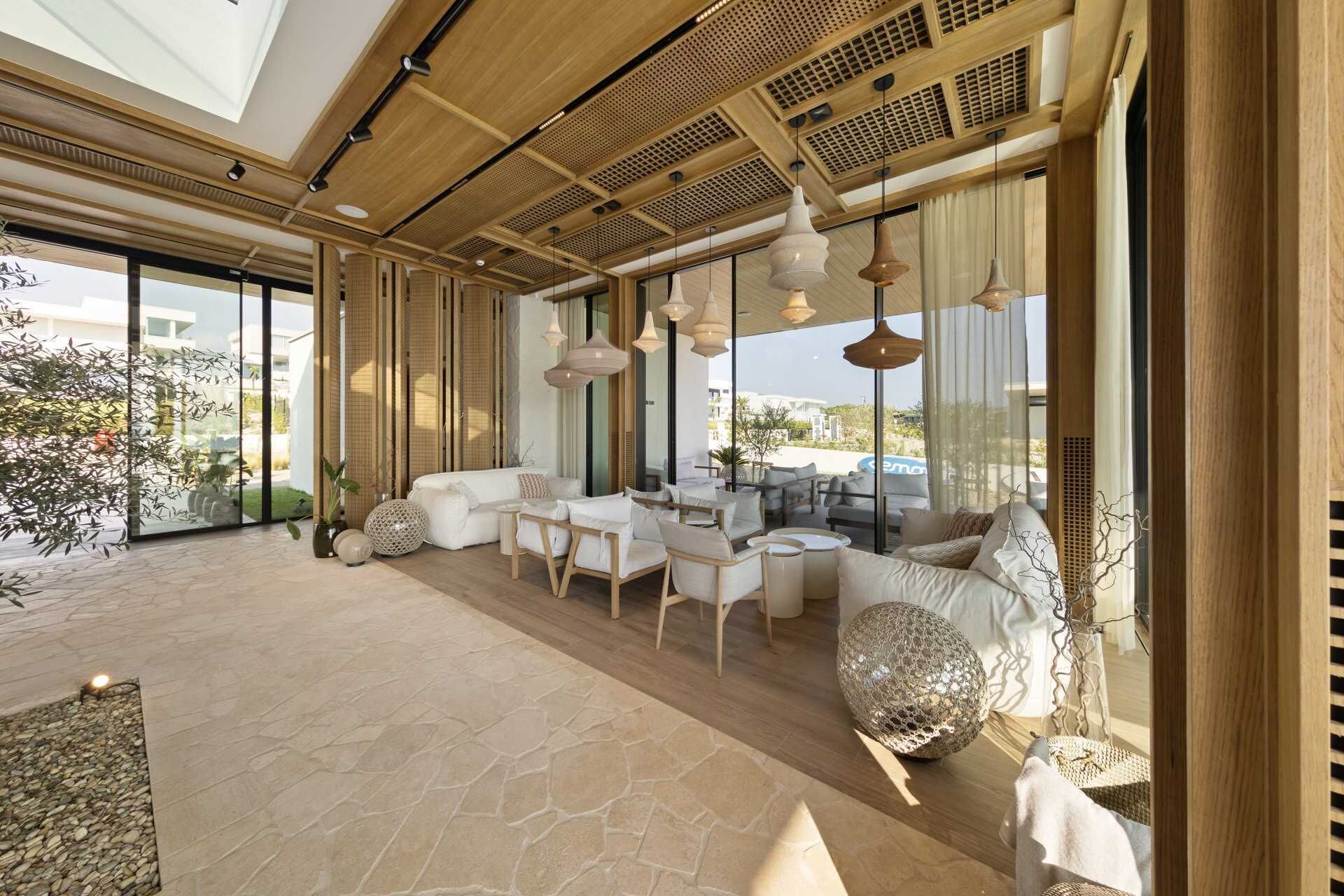 Amplia sala de estar con techo alto, ventanas grandes y vistas al exterior.