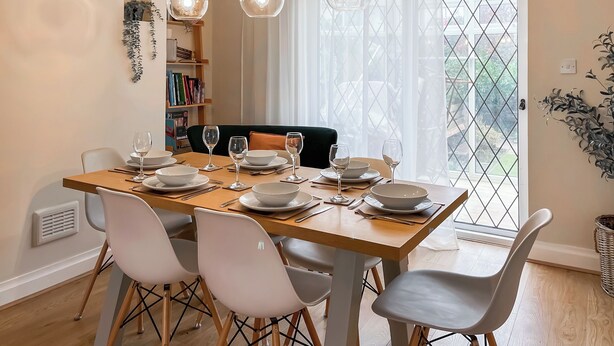 A dining area with a wooden table set for four, surrounded by modern chairs. - 3 bedroom accommodation in Keswick (Keswick)