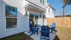 A house with a covered patio area, a wooden fence, and outdoor seating. - Dreamland in the Brooklyn Arts District (Wilmington)