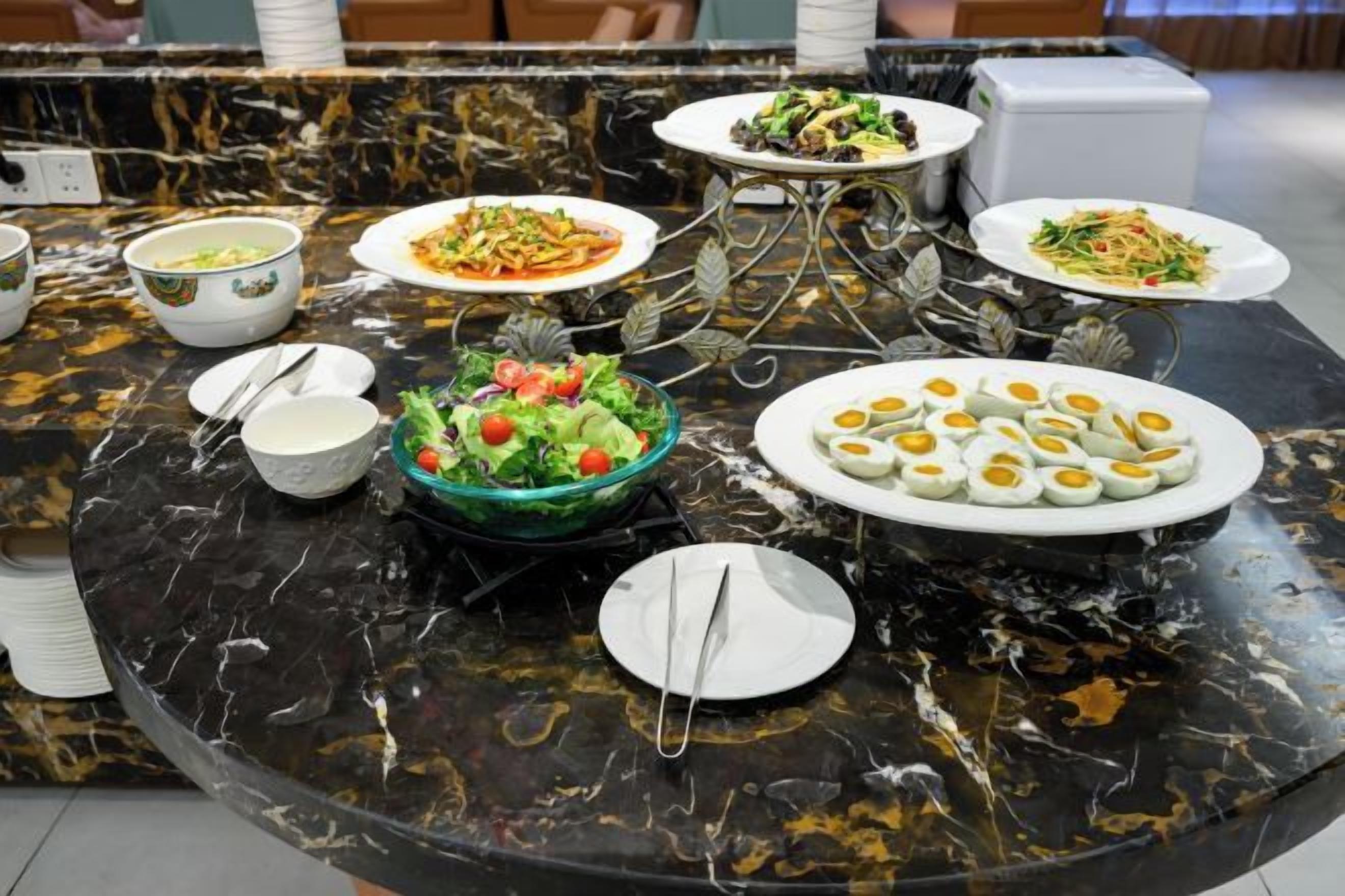 A marble table with various dishes and bowls, likely in a hotel or restaurant setting.