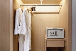 A bathroom with a wooden vanity, a towel rack with white towels, and a hairdryer.