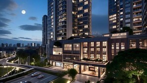 Un immeuble moderne à plusieurs étages, doté de grandes fenêtres et d’une façade bien éclairée.