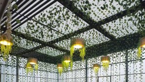 A banquet hall with round tables covered in white tablecloths and gold sashes, surrounded by chairs. - The Elgin Hotel (Kolkata)