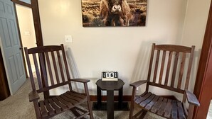 A room with two wooden chairs, a small table, and a wall-mounted picture of a yak. - Cozy Corner Cottage - 4 Bed/2 Bath
No Cleaning Fee! (Salina)